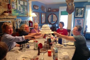 Nimrod Hall writers lifting fake wedding cake at breakfast table