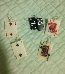 necklaces and earrings that look like playing cards and dominoes, worn due to superstitions