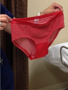 Forensic nurse holding a pair of red women's bikini briefs